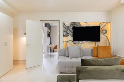 a living room with a couch and a tv on a wall at Cosmo Apartments Rambla Catalunya in Barcelona