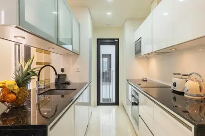 a kitchen with white cabinets and black counter tops at Cosmo Apartments Rambla Catalunya in Barcelona
