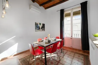 a dining room with a table and red chairs at AB Gran de Gràcia in Barcelona