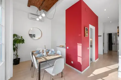 a dining room with a red wall and a table at AB Gran de Gràcia in Barcelona