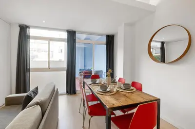 a living room with a table and a couch and a mirror at AB Gran de Gràcia in Barcelona