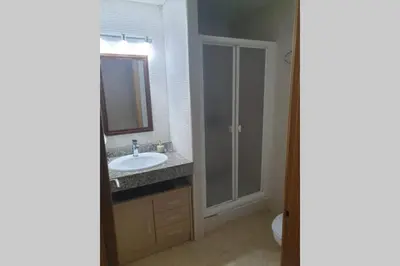 a bathroom with a sink and a mirror and a toilet at Apartamento para 5 personas frente al mar con piscina y parking in Cubelles