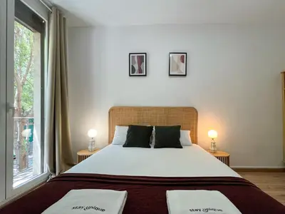 a bedroom with a large bed and a window at Stay U-nique Apartments Urgell in Barcelona
