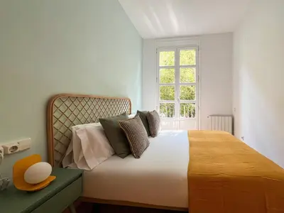 a bedroom with a bed with pillows and a window at Stay U-nique Apartments Urgell in Barcelona