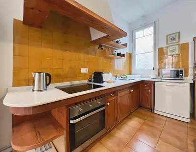 a kitchen with wooden cabinets and a counter top at Stay U-nique Apartments Rogent in Barcelona