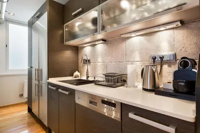 a kitchen with stainless steel appliances and brown cabinets at Stay U-nique Apartments Sardenya in Barcelona