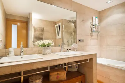 a bathroom with two sinks and a mirror and a tub at Stay U-nique Apartments Sardenya in Barcelona