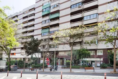 an apartment building with trees in front of it at Stay U-nique Apartments Sardenya in Barcelona