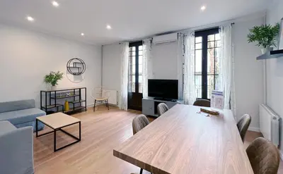 a living room with a table and a couch at Stay U-nique Apartments Travessera in Barcelona