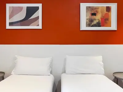 two beds in a room with two pictures on the wall at Stay U-nique Apartments Travessera in Barcelona