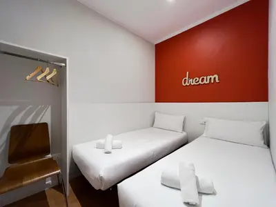 two beds in a room with a sign on the wall at Stay U-nique Apartments Travessera in Barcelona