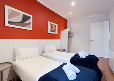 two beds in a room with red walls at Stay U-nique Apartments Travessera in Barcelona