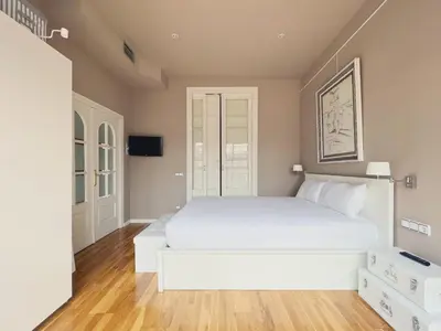 a bedroom with a white bed and a flat screen tv at Stay U-nique Apartments Urquinaona in Barcelona