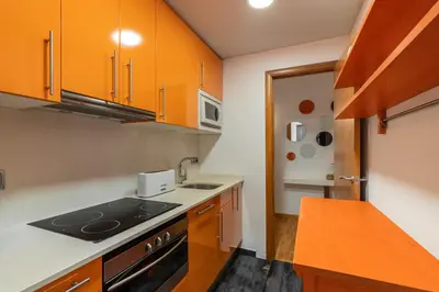 a kitchen with orange cabinets and a stove top oven at Stay U-nique Apartments Salva II in Barcelona