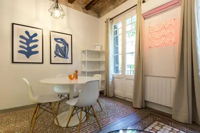 a dining room with a table and chairs and a window at Stay Unique Apartments Corsega in Barcelona