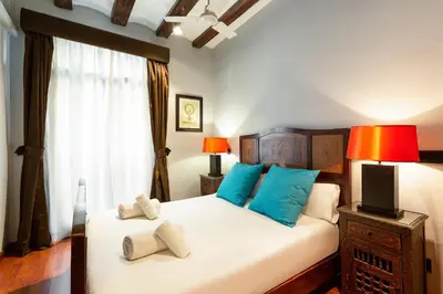 a bedroom with a bed with blue pillows and a television at Stay U-nique Apartments Obradors in Barcelona