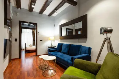 a living room with a blue couch and a mirror at Stay U-nique Apartments Obradors in Barcelona
