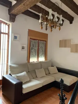 a living room with a couch and a chandelier at CASA la PAU in Vilassar de Mar