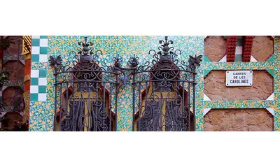 a gate with a tile wall with a sign on it at Atic Gaudi-Gracia in Barcelona