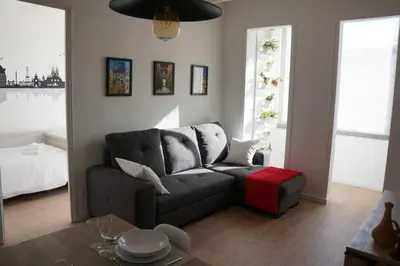a living room with a gray couch and a red ottoman at Barcelona Industrial Style Apartment in Hospitalet de Llobregat
