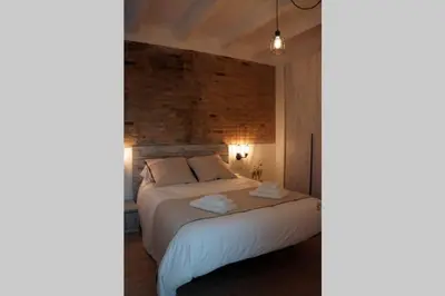 a bedroom with a bed with white sheets and pillows at Barcelona Industrial Style Apartment in Hospitalet de Llobregat