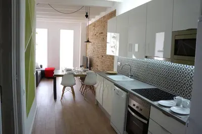 a kitchen with a counter and a table with chairs at Barcelona Industrial Style Apartment in Hospitalet de Llobregat