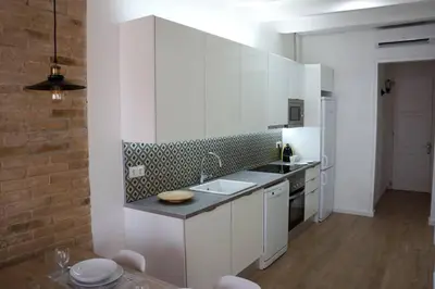 a white kitchen with a sink and a counter at Barcelona Industrial Style Apartment in Hospitalet de Llobregat