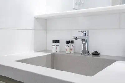a kitchen sink with three bottles of toothpaste at Kronos on the beach Suite 4 in Barcelona