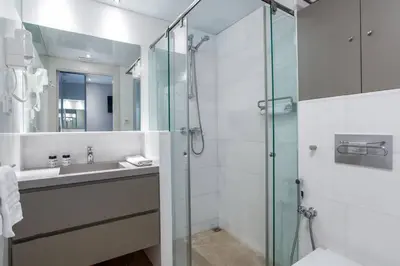 a bathroom with a glass shower and a sink at Kronos on the beach Suite 4 in Barcelona