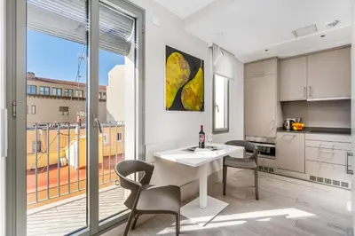 a kitchen and dining room with a white table and chairs at Kronos on the beach Suite 4 in Barcelona