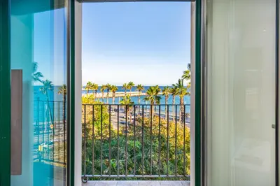 a sliding glass door with a view of the beach at Kronos on the beach Suite 4 in Barcelona