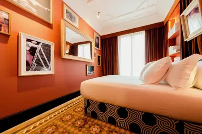 a bedroom with orange walls and a bed with pillows at One Shot Aragó in Barcelona
