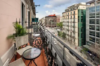 a balcony with tables and chairs on a city street at One Shot Aragó in Barcelona