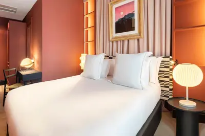 a bedroom with a large white bed and a table at One Shot Aragó in Barcelona
