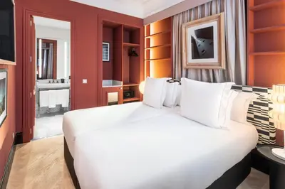 a large white bed in a room with a bathroom at One Shot Aragó in Barcelona
