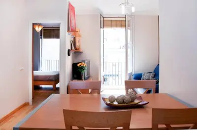 a dining room with a table and chairs and a living room at Bbarcelonapartment Acogedor, tranquilo con Balcón in Barcelona