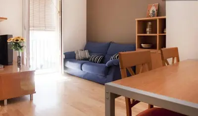 a living room with a blue couch and a table at Bbarcelonapartment Acogedor, tranquilo con Balcón in Barcelona