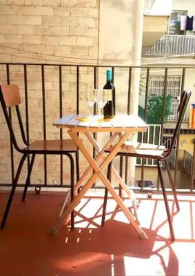 a table with a bottle of wine and two chairs at Bbarcelonapartment Acogedor, tranquilo con Balcón in Barcelona