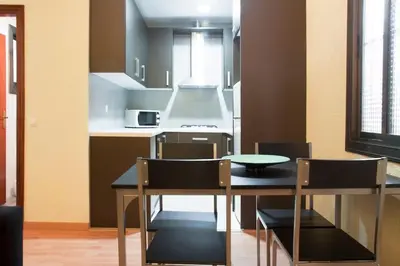 a kitchen with a table and chairs in a room at Apartamento Cerca del Mar in Badalona