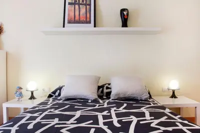 a bedroom with a black and white bed with two pillows at Apartamento Cerca del Mar in Badalona