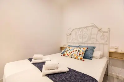 a bedroom with a white bed with towels on it at Pere Serafi 2 bedroom apartment in Barcelona
