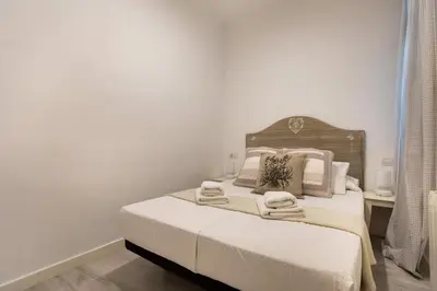 a bedroom with a bed with white sheets and pillows at Pere Serafi 2 bedroom apartment in Barcelona