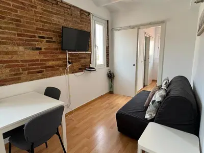 a living room with a couch and a brick wall at Ático ideal en Barcelona in Barcelona