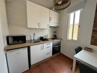 a kitchen with white cabinets and a sink and a microwave at Ático ideal en Barcelona in Barcelona
