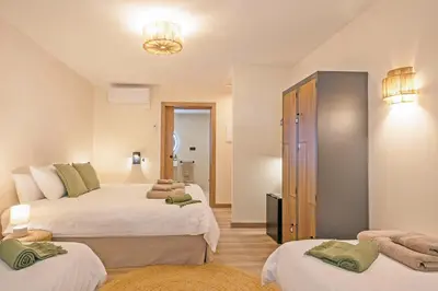 a hotel room with two beds and a bathroom at Olivia Barcelona in Barcelona
