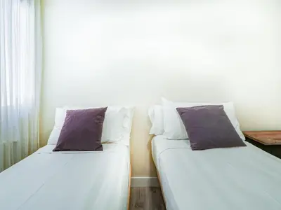 two beds sitting next to each other in a room at Beach Matucana Apartment by Hello Homes Sitges in Sitges