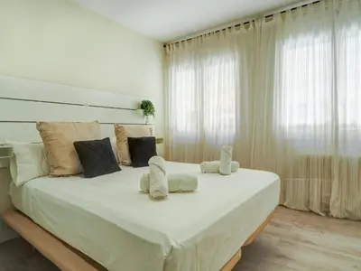 a bedroom with a large bed with white sheets and pillows at Beach Matucana Apartment by Hello Homes Sitges in Sitges