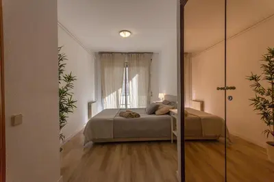 a bedroom with a bed in a room with a mirror at INNOUTHOME Apartamento Eixample Barcelona in Barcelona