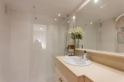 a white bathroom with a sink and a mirror at INNOUTHOME Apartamento Eixample Barcelona in Barcelona