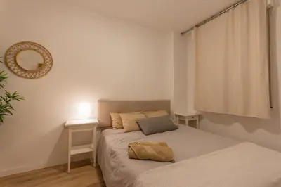 a small bedroom with a bed and a mirror at INNOUTHOME Apartamento Eixample Barcelona in Barcelona